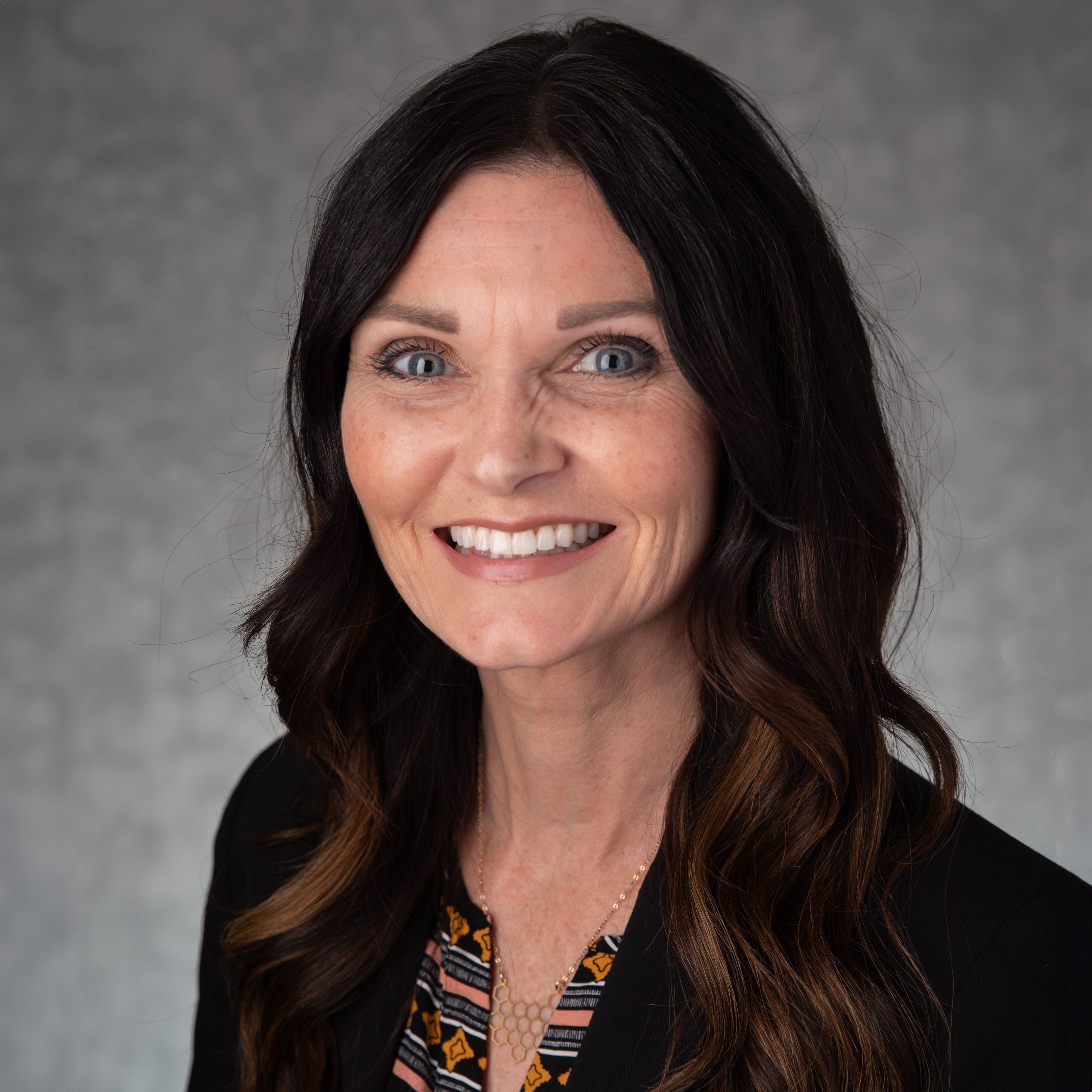 Kendra Stanley-Mills in dark shirt, smiling