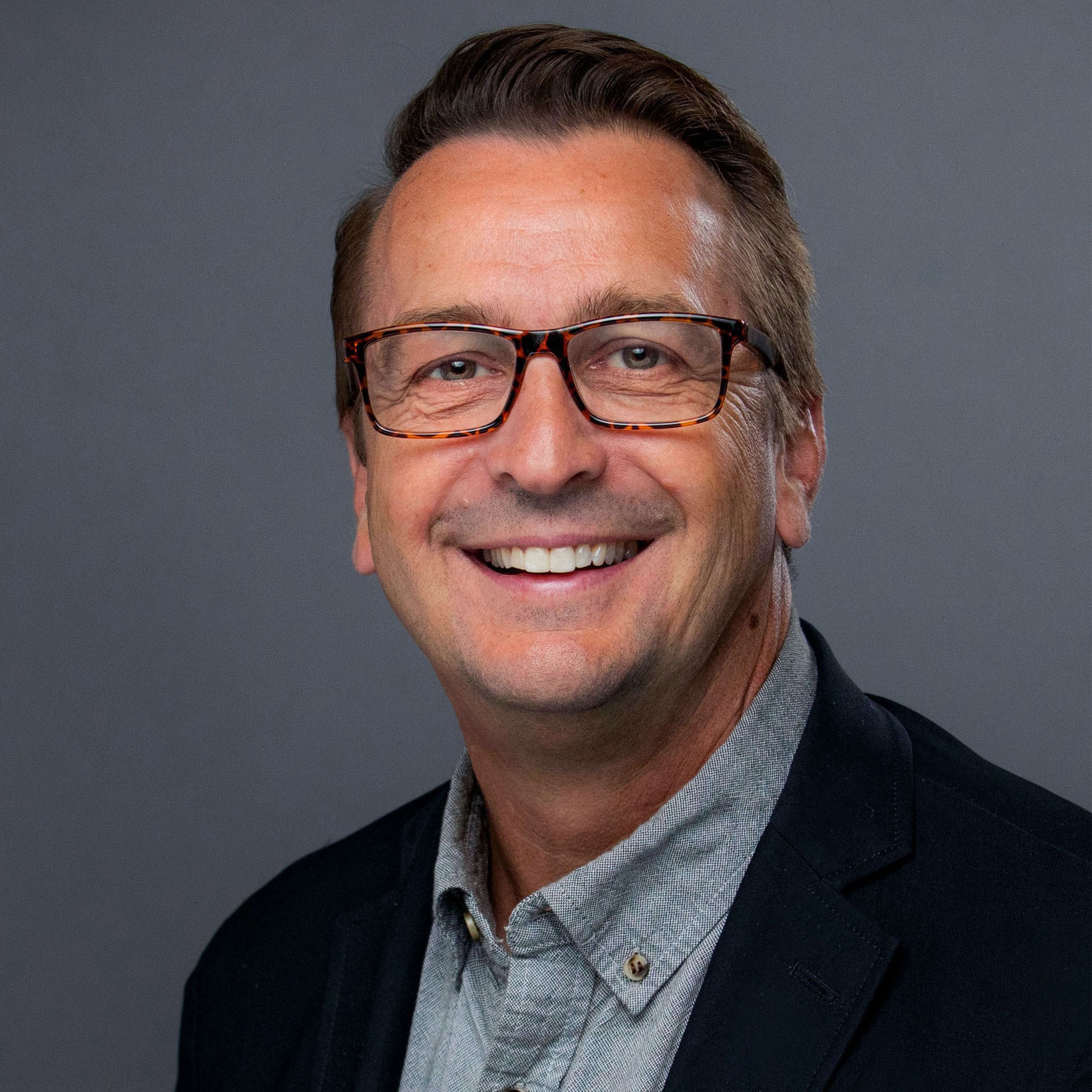 Bill Cuppy in black jacket and gray shirt, smiling