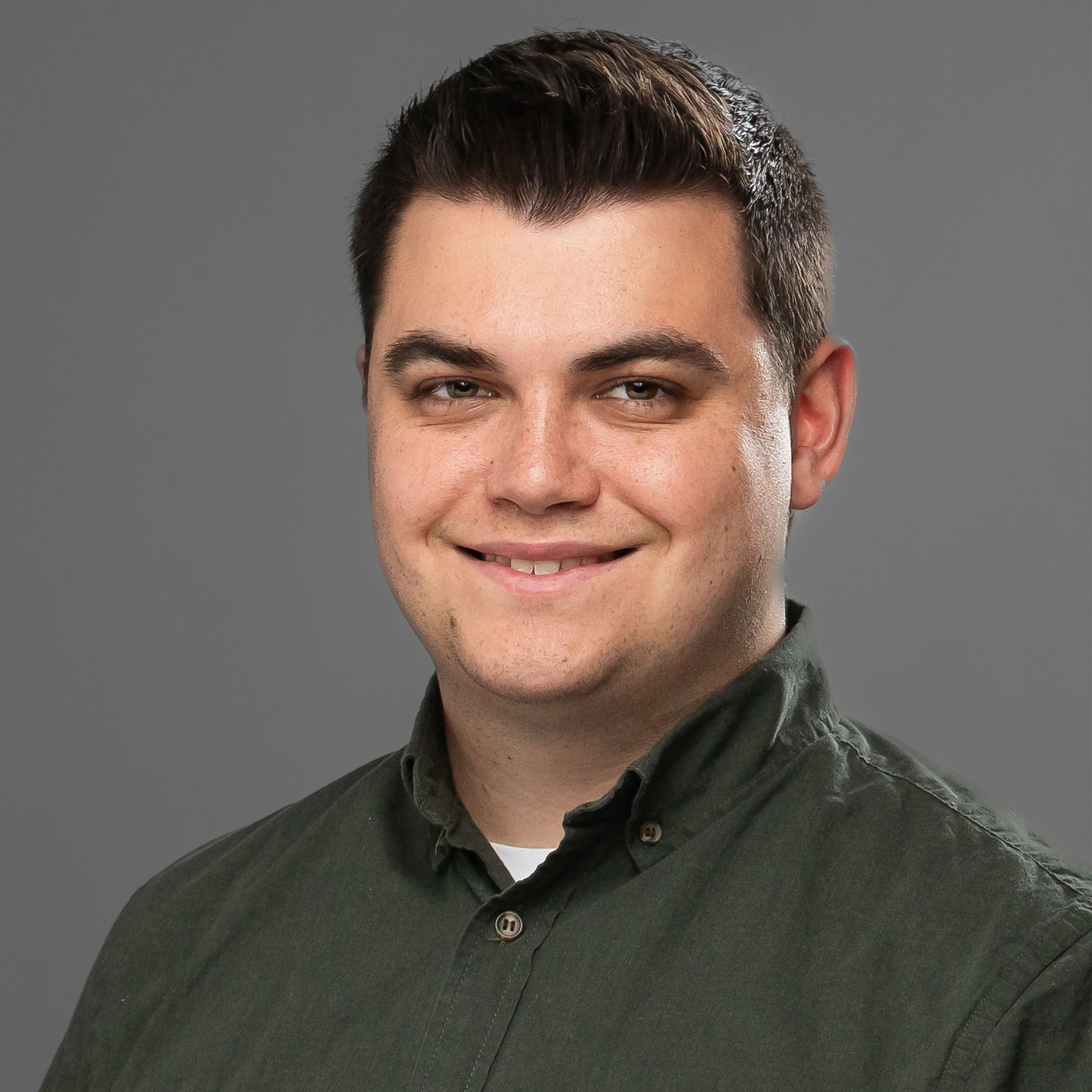 Thomas Chavez, smiling, wearing a dark green button up shirt