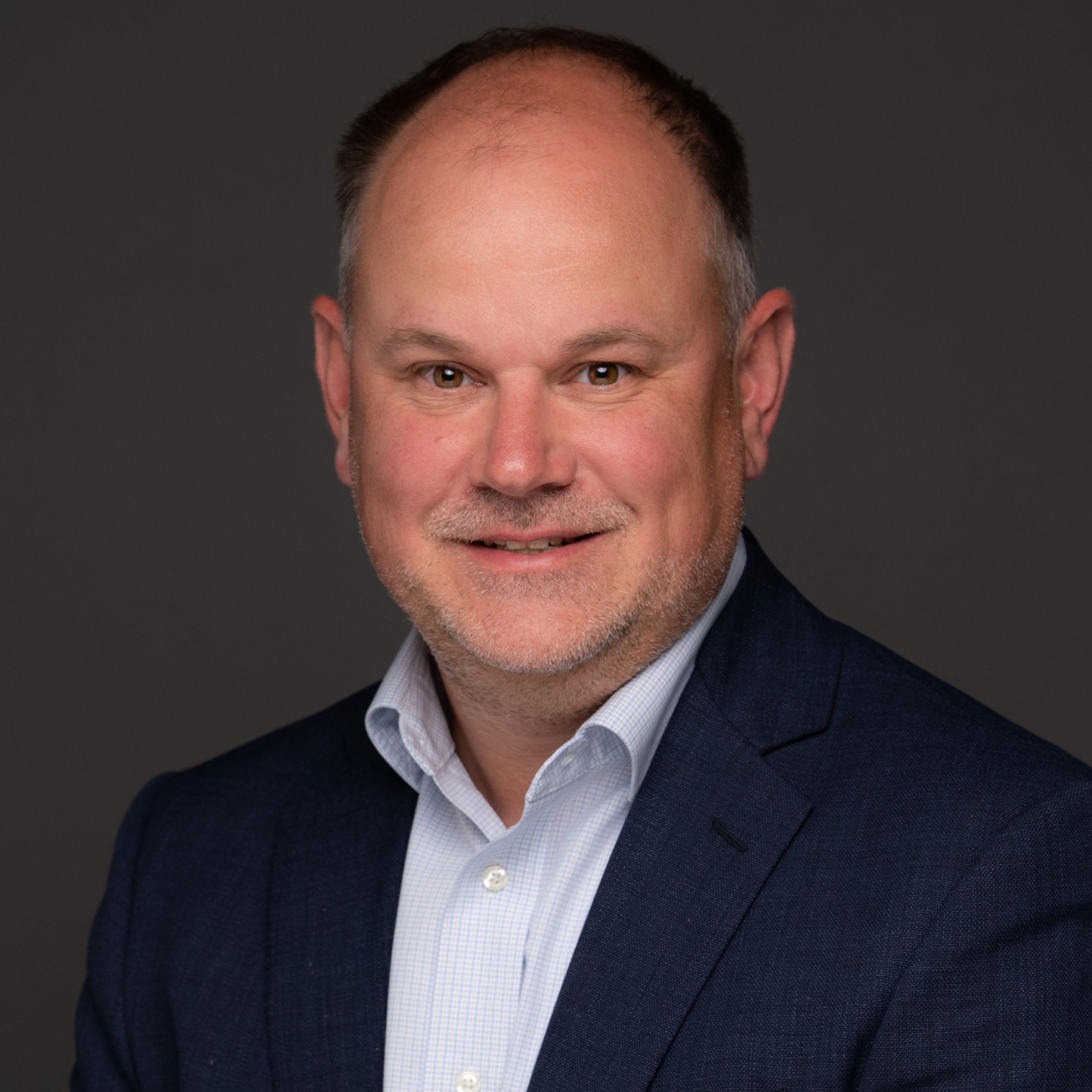 Chris Knape in blue blazer, smiling