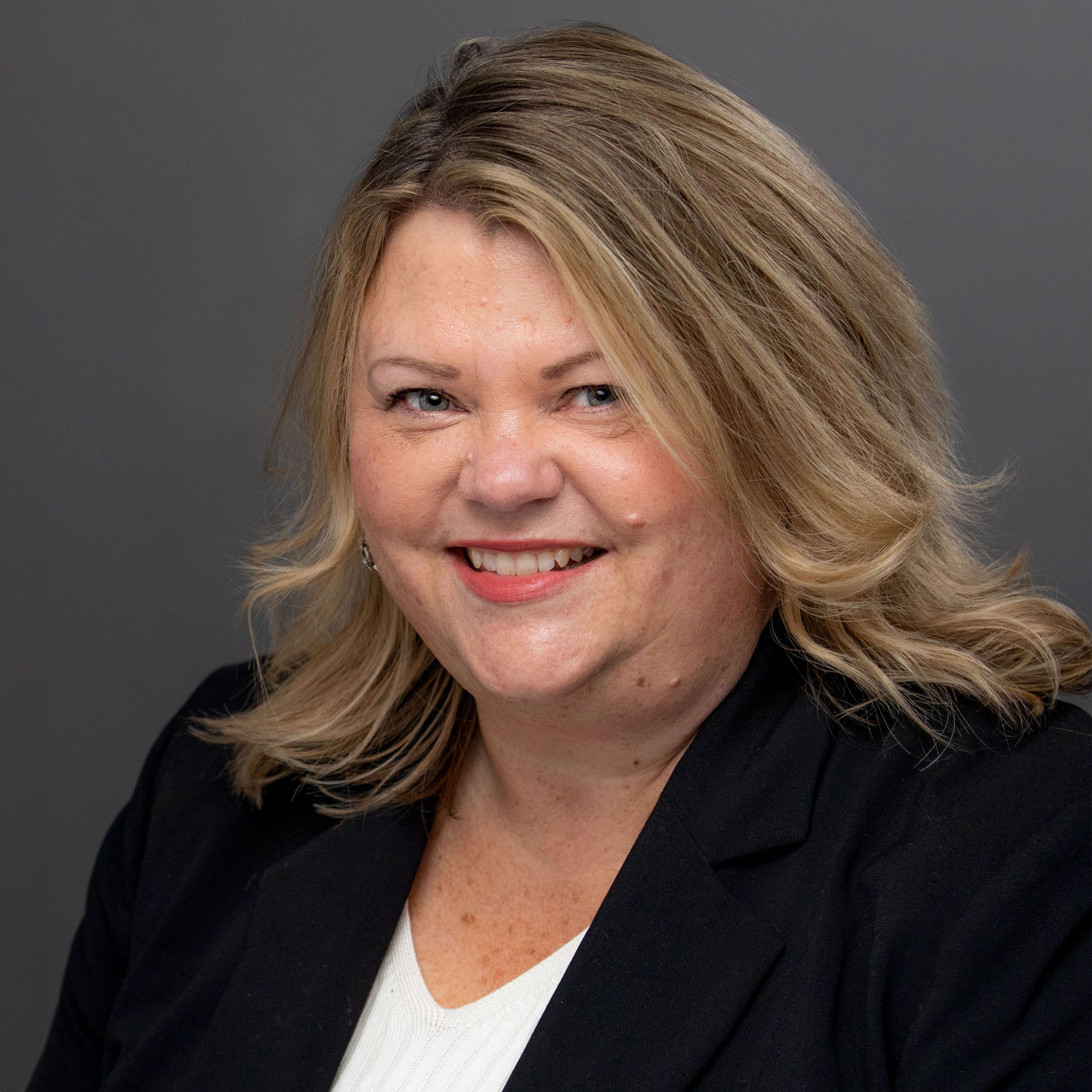 Peg West in dark blazer smiling