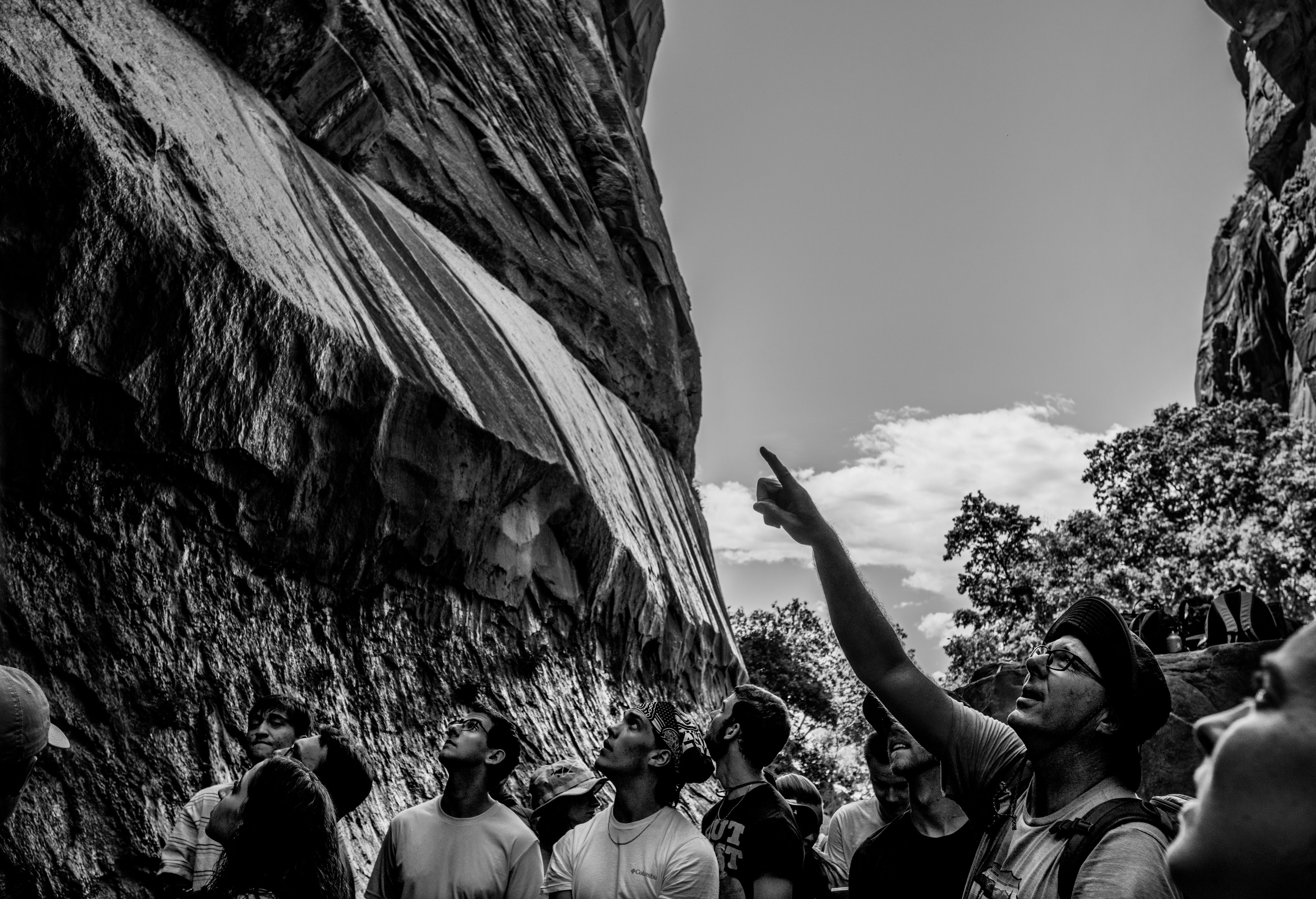 Peter Riemersma points to rock formations to group standing in canyon dip