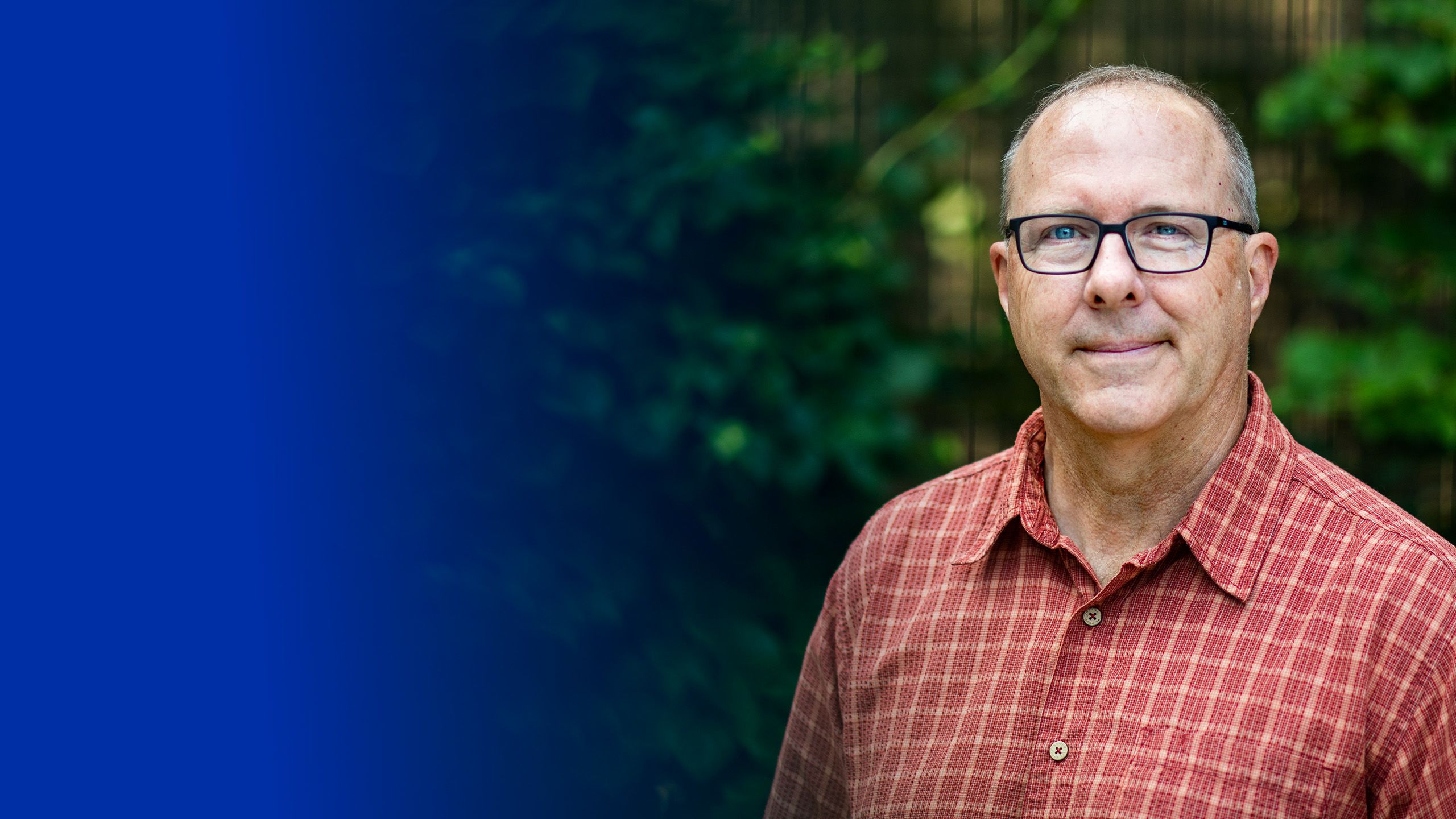 Peter Riemersma seated on concrete entryway, with big decorative rocks nearby