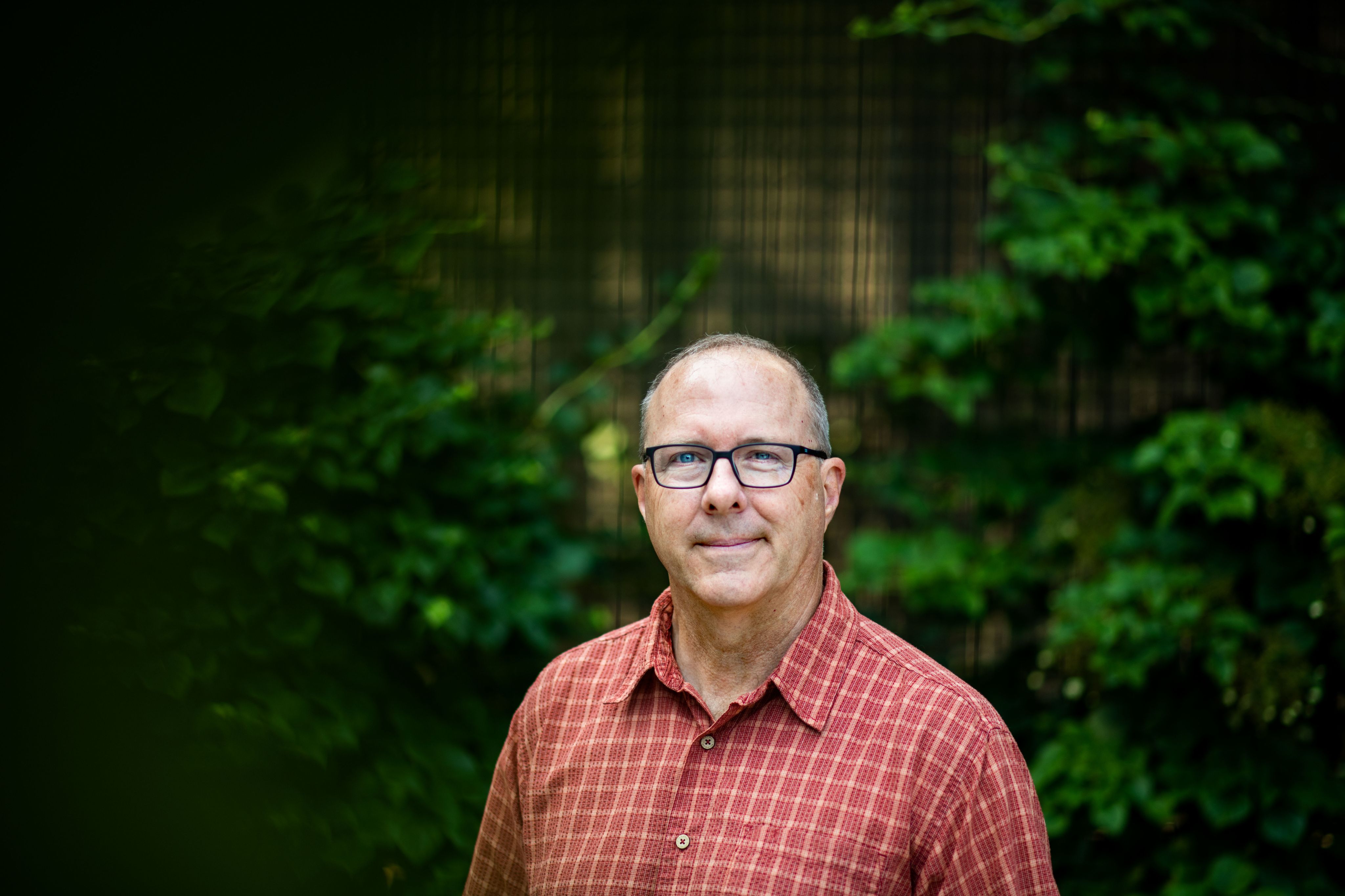 Peter Riemersma seated on concrete entryway, with big decorative rocks nearby