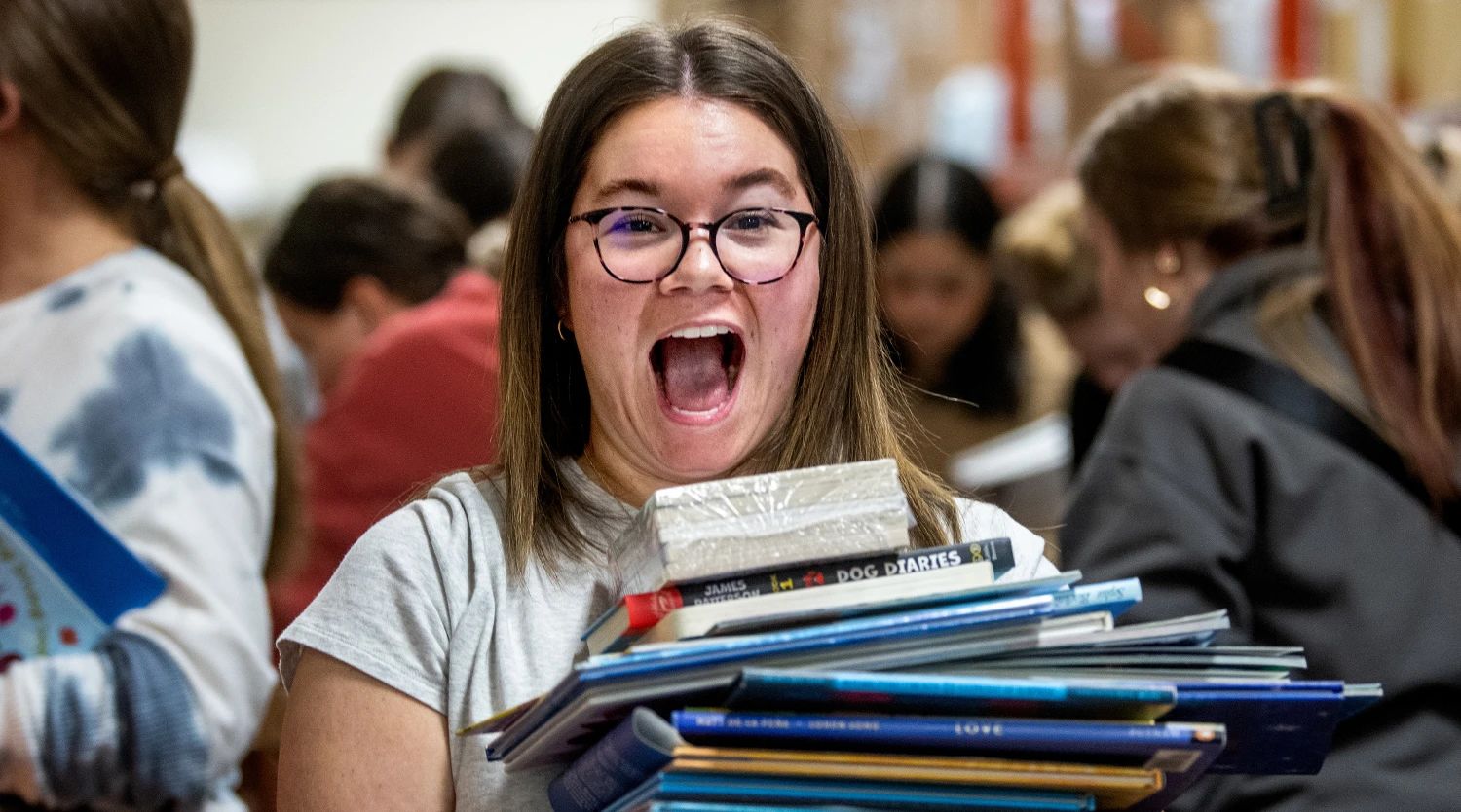 Rhianna Furness, a senior special education major, reacts to the stack of books she picked out.