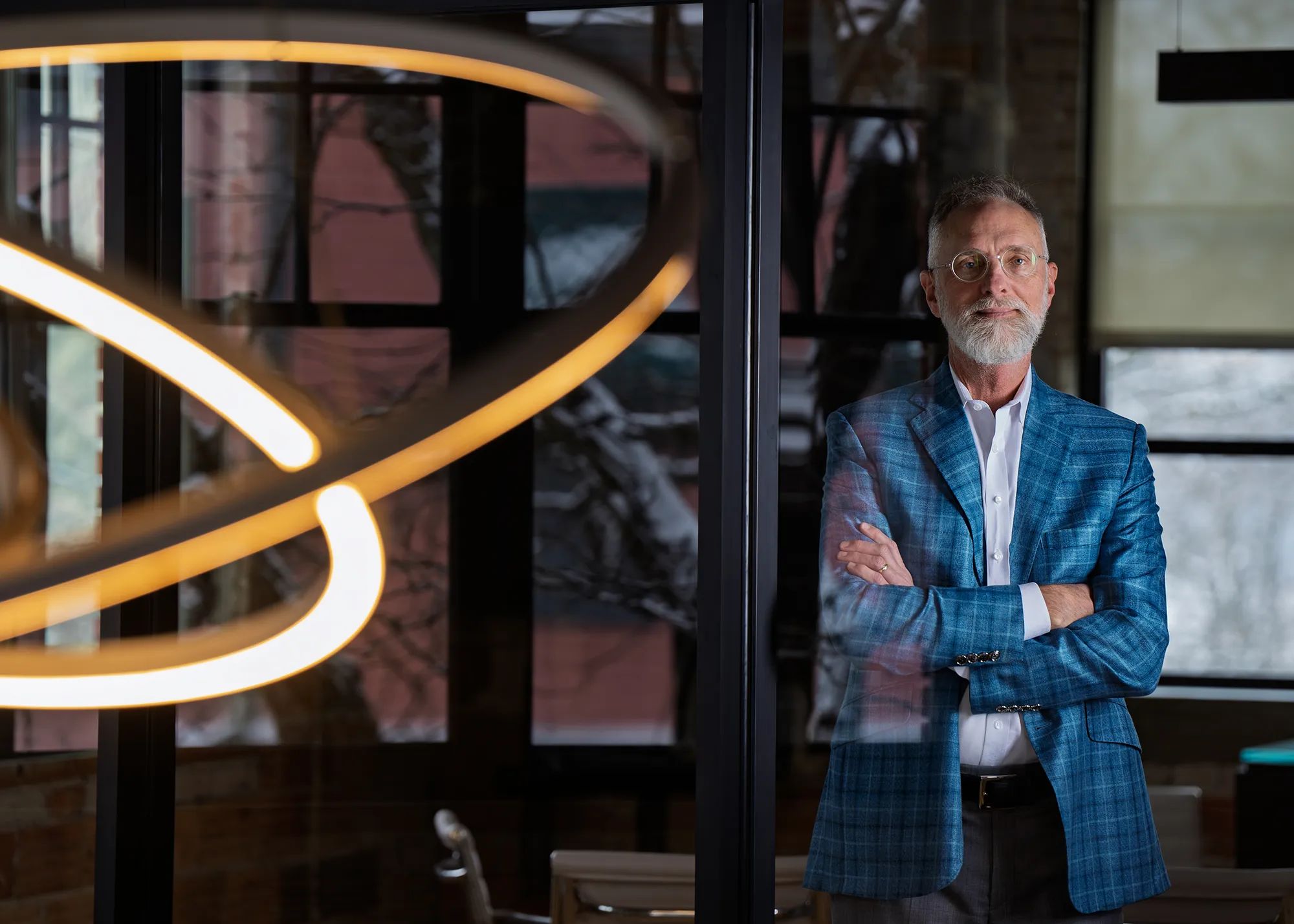 Carl Erickson, with glasses and blue patterned suitcoat, is pictured at Atomic Object in Grand Rapids