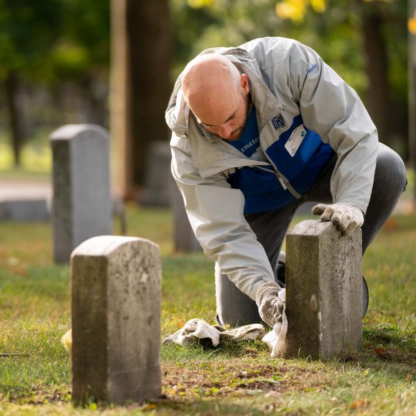 Members of College of Education and Community Innovation clean gravestones
