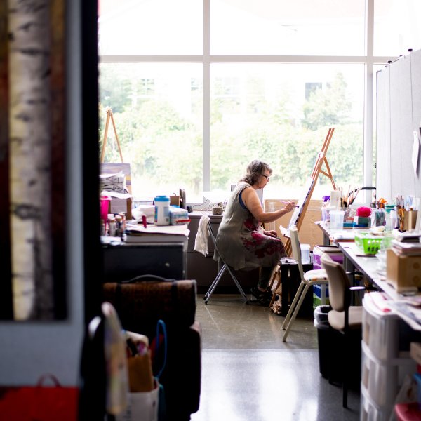 Lynn Frisinger Stribley paints in her studio space that she rents from the GVSU Muskegon Innovation Hub.