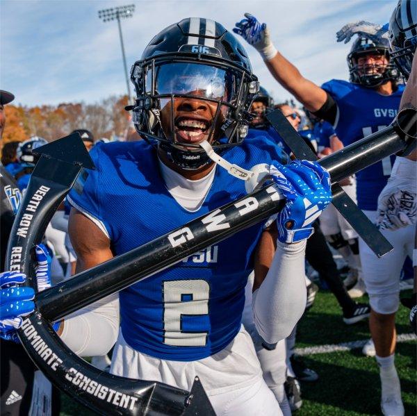 A Grand Valley football player celebrates a big play with a team trophy.
