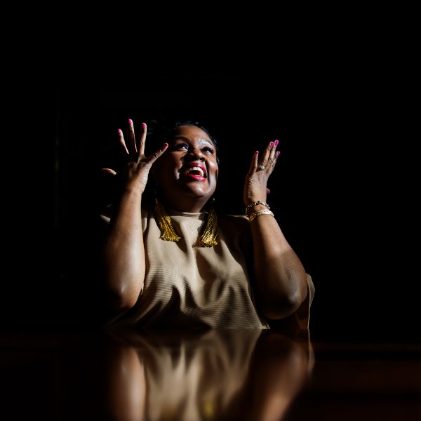 portrait of Shannon Cohen seated at table, hands in the air