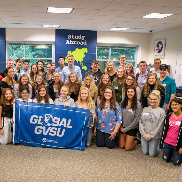 group of 40 students holding GVSU Global flag