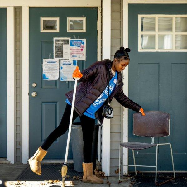 Student Braya Wright sweeps outside of the ICCF Community Homes