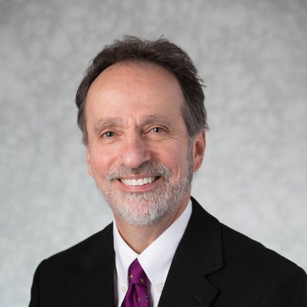 A person smiles in a posed head shot.