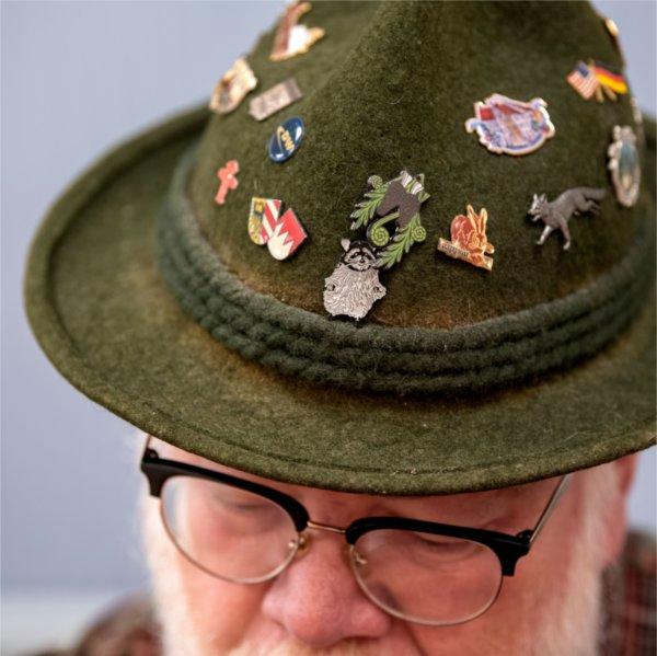 A student is silhouetted against a red backdrop while holding a colorful fan.
