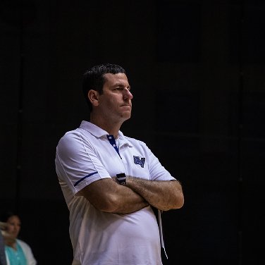 Jason Johnson standing with arms crossed at a game.