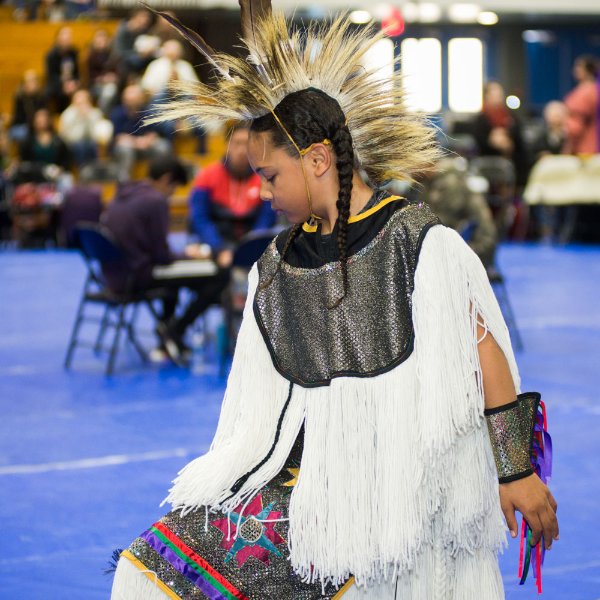 participant in a GVSU pow wow, wearing white native regalia