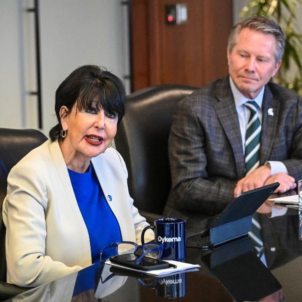 President Philomena V. Mantella at a conference table next to MSU President Kevin M. Guskiewicz