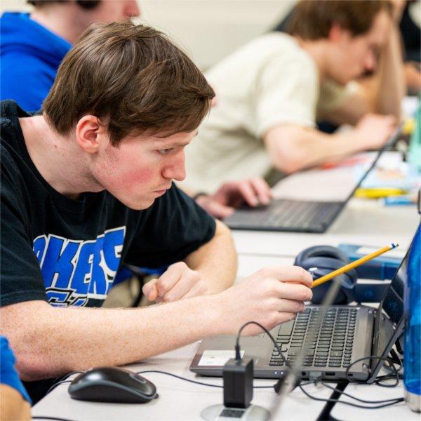 student points to laptop screen in computer lab