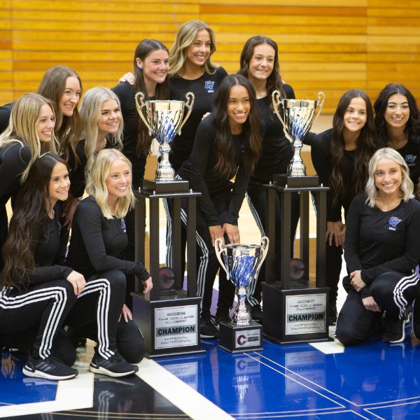 Members of Lakers Dance Team pose with national championships trophies.