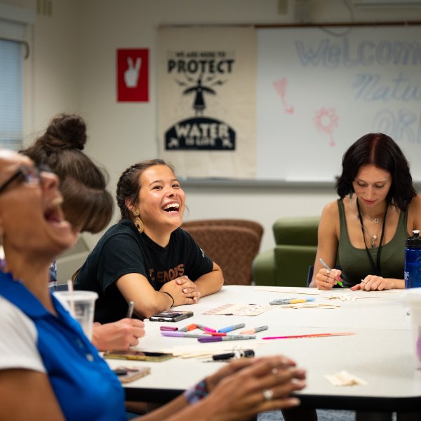 Lin Bardwell, assistant director of the Office of Multicultural Affairs, left, laughs with students Carson Brunette and Kelly Elswick, center, during a Maajtaadaa! Orientation event August 20 in the new space in North C.