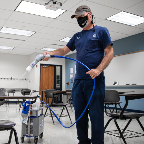 Photo of employee cleaning a classroom.