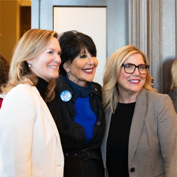 Three people smile while posing for a photo.