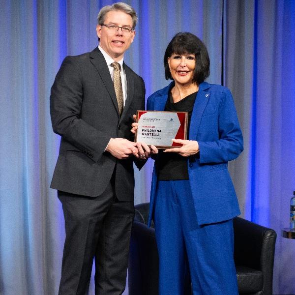 Crain's Executive Editor Mickey Ciokajlo poses while presenting GVSU President Philomena V. Mantella with a Newsmaker of the Year plaque.