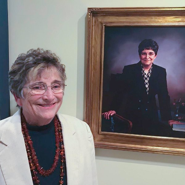 Johnine Callahan, retired professor and honors college director, stands next to her portrait in Niemeyer Living Center at the 10th anniversary of the honors college.