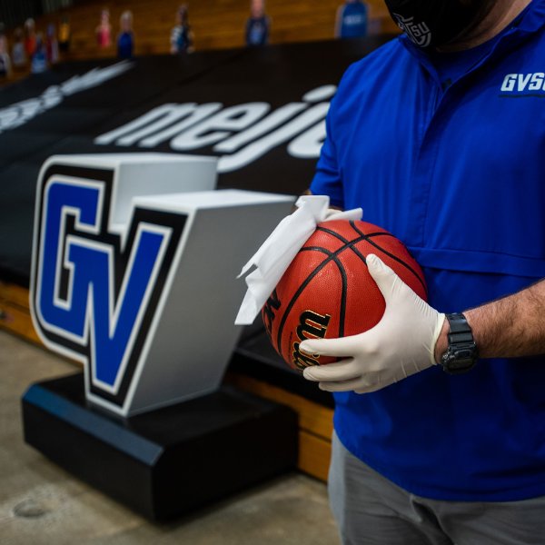 sanitizing the basketball by person wearing gloves