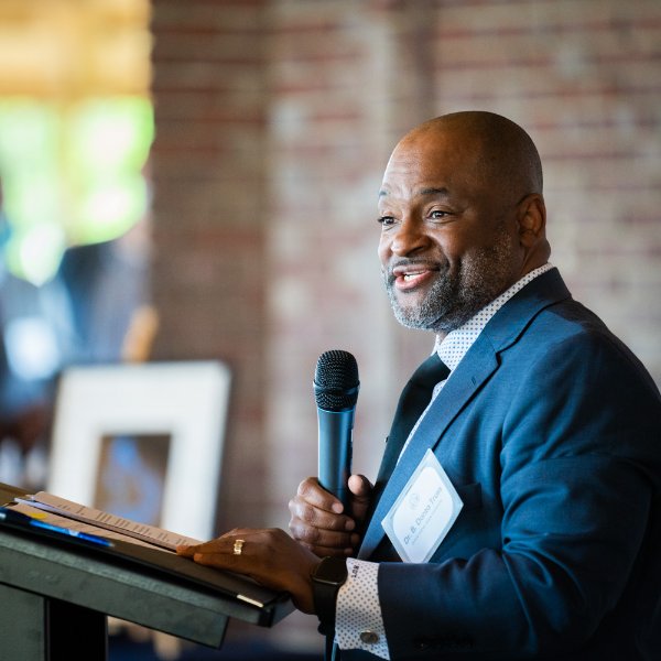 Vice president B. Donta Truss stands at a podium with a microphone