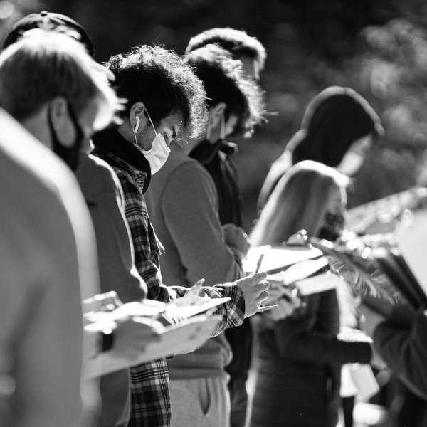 Students on Grand Valley's Allendale Campus fill out clipboards to register to vote on Election Day in November 2020