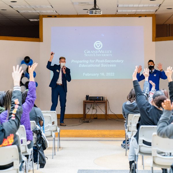 room full of students listening to 2 presenters, screen reads Preparing for Post-Secondary Educational Success