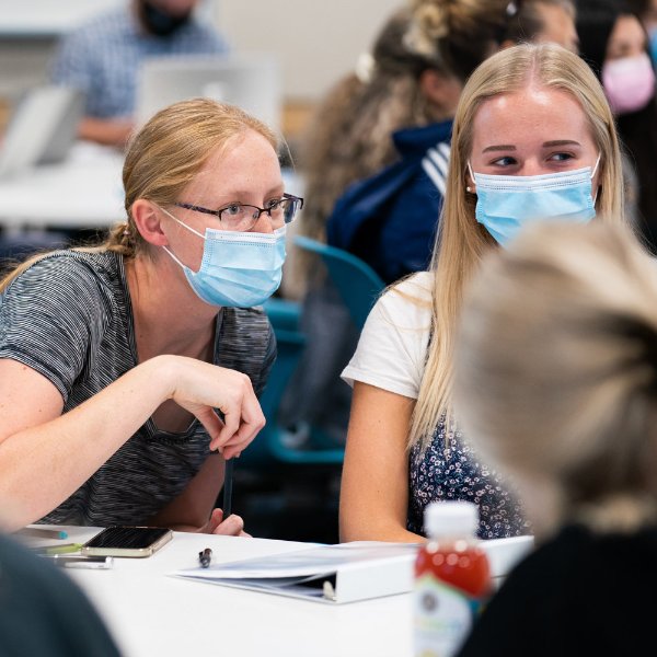 Students socializing at a table in the DeVos Center for Interprofessional Health.