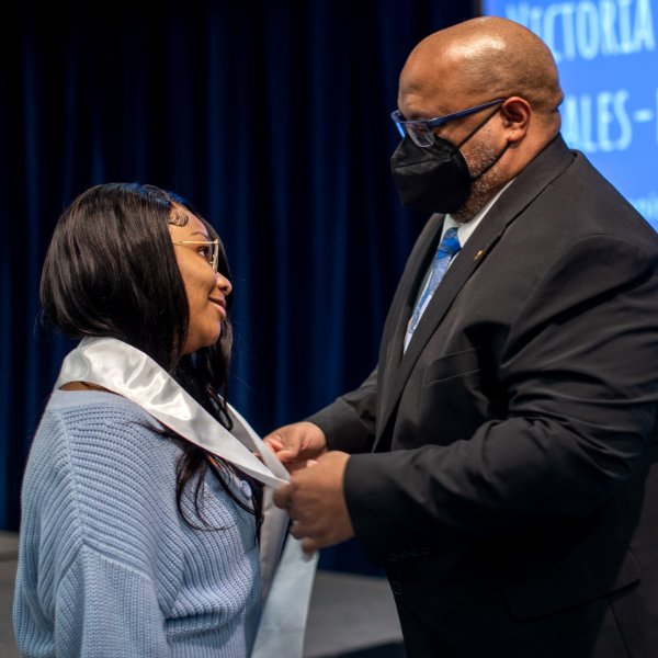 Dr. William Washington, TRIO program director, right, places a graduation stole on Brianna McKinney during the TRIO academic achievement ceremony at GVSU on April 15.