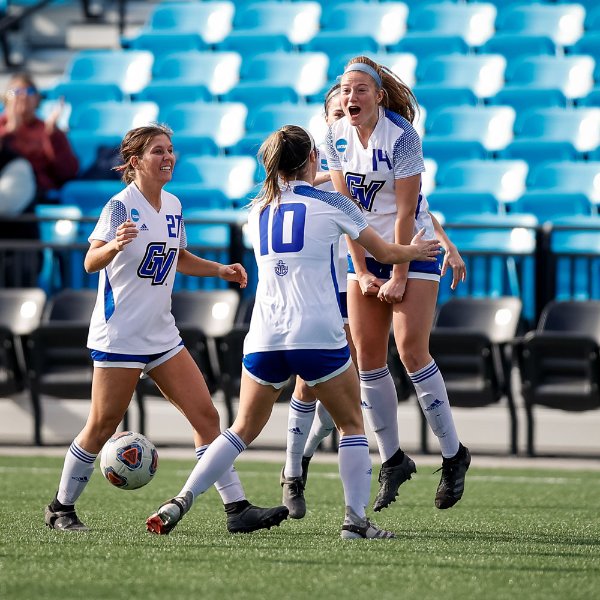 Soccer players celebrate a goal