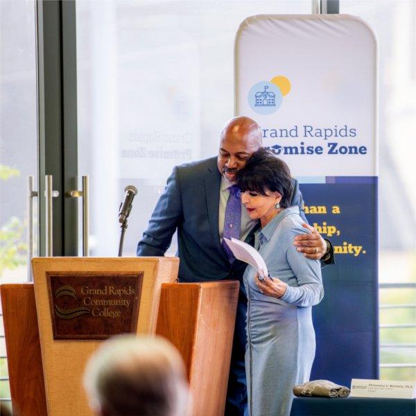 President Philomena V. Mantella and Ferris State President Bill Pink hug during the Promise Zone announcement