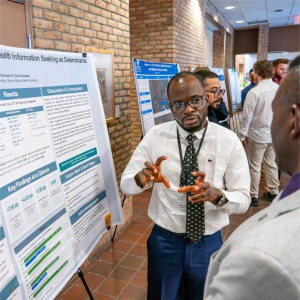 A student discusses his capstone project with a faculty member.
