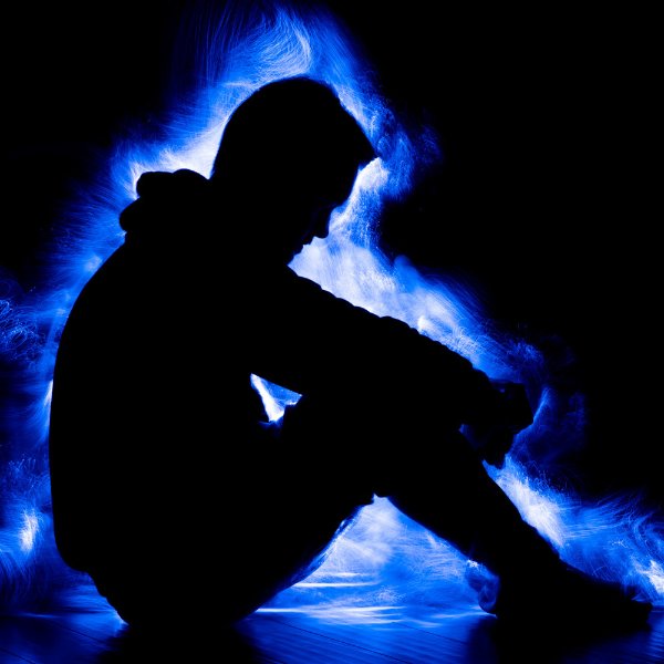 A silhouette of a person with blue light around them.