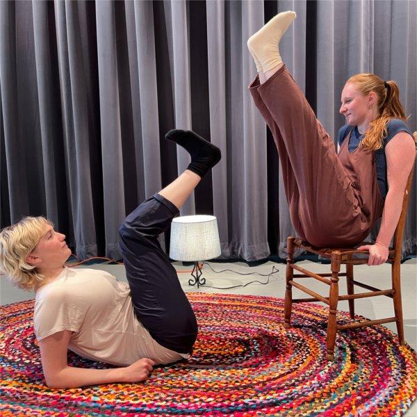 Kaye Suarez and O�Malley Ferguson perform a dance on stage, Kaye on left on floor with legs up, O'Malley on chair with legs up