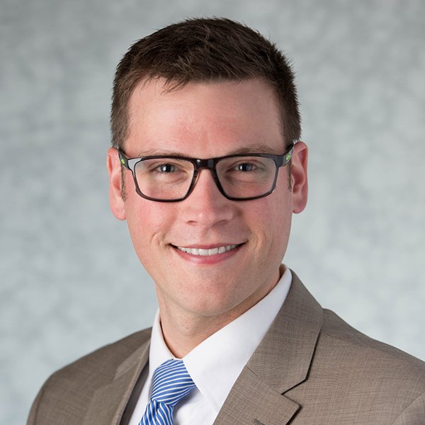 Kris Pachla smiles in a posed studio portrait.
