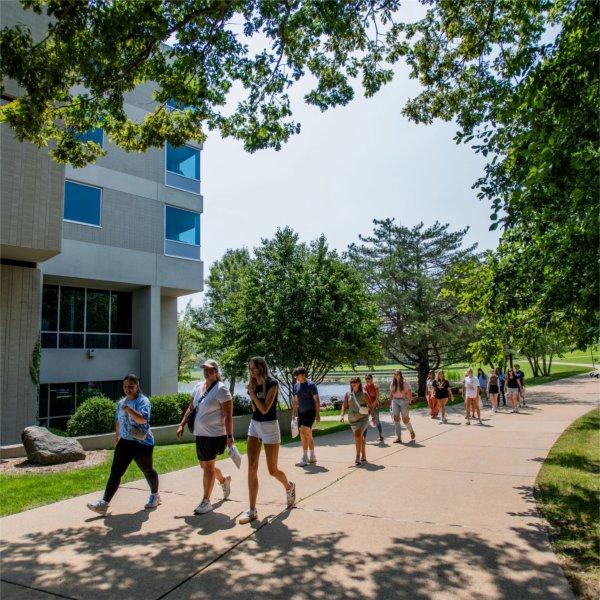 students walking on sidewalk by Zumberge Hall
