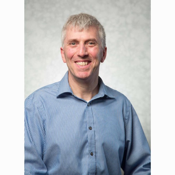 Jeff Kelly Lowenstein smiles in a posed portrait.