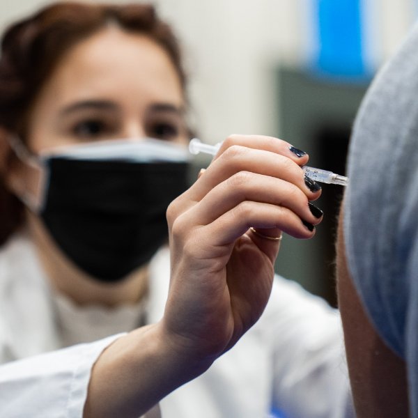 A student in the Physician Assistant Studies program gives a COVID-19 vaccination shot.