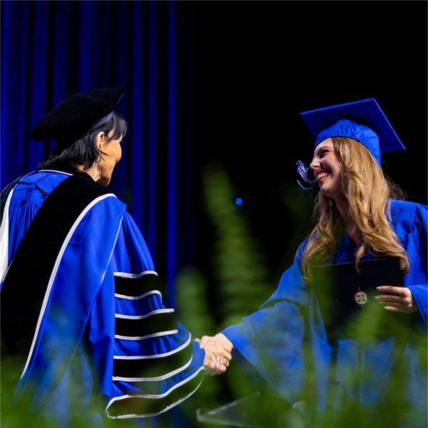 A graduate shakes President Mantella's hand during Commencement.