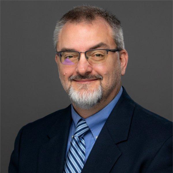 A person smiles while posing for a photo.