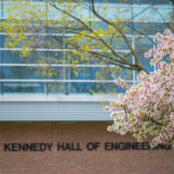 flowering trees in spring in front of Kennedy Hall of Engineering building and signage