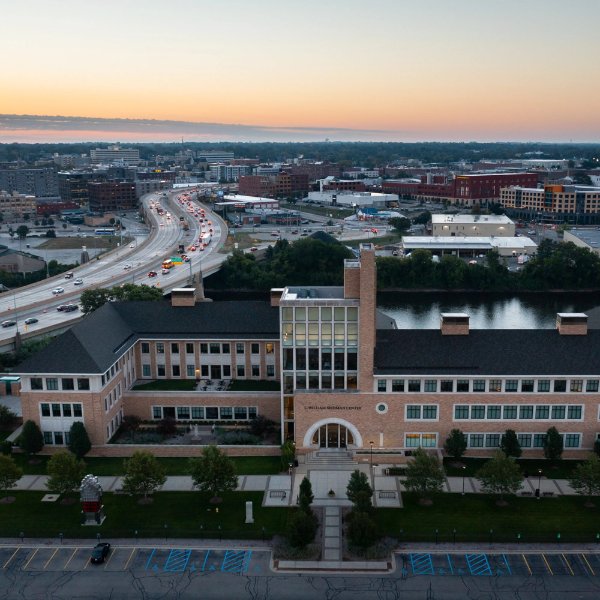 Seidman College of Business building against sunrise in background and highway on left