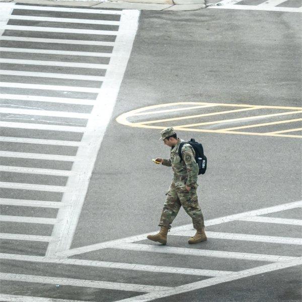 A military member crosses the street.