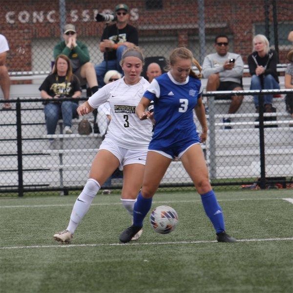 A member of the Purdue Northwest women's soccer team battles for possession of the ball against a member of the GVSU women's soccer team.
