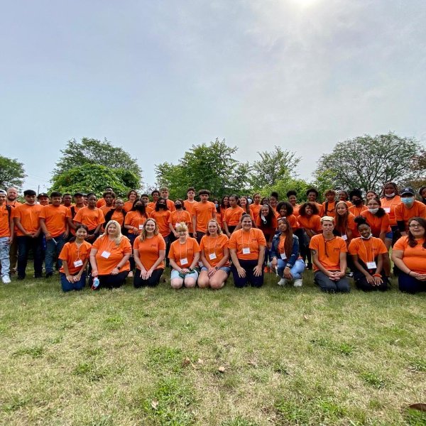 Group of high school students in orange shirts and staff members at the ExCEL Camp.